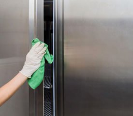 Trabajador limpiando polvo de una superficie de acero inoxidable