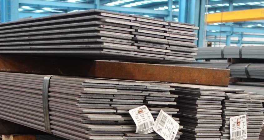 Piezas de solera de acero apiladas dentro de una bodega