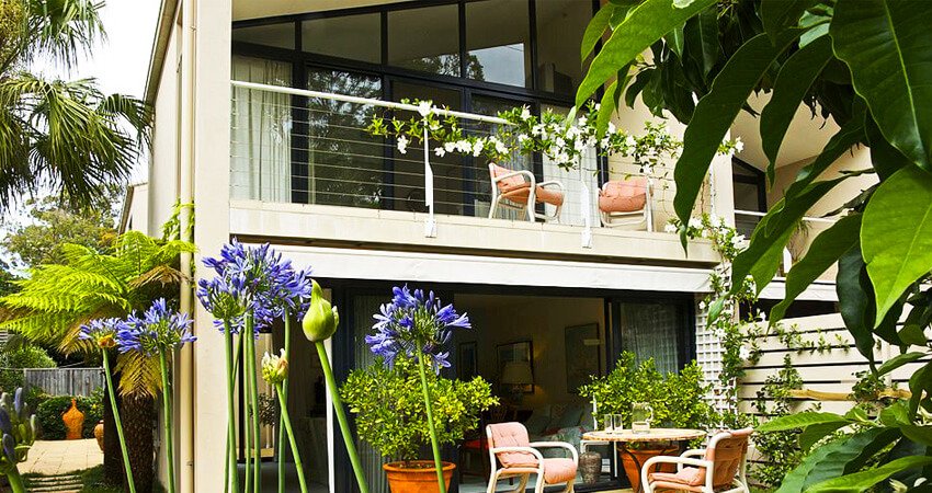 Balcón moderno en la parte lateral de una casa de dos pisos - barandales de herrería para balcones modernos