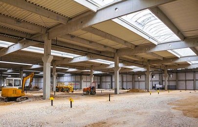 Trabajadores llevando a cabo la construcción de una nave industrial con piezas de acero