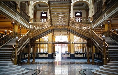 La escalera imperial se desplanta desde el centro de la habitación y se divide en dos tramos en direcciones opuestas