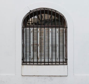 Protecciones de herrería con arco color negro instaladas en un muro blanco