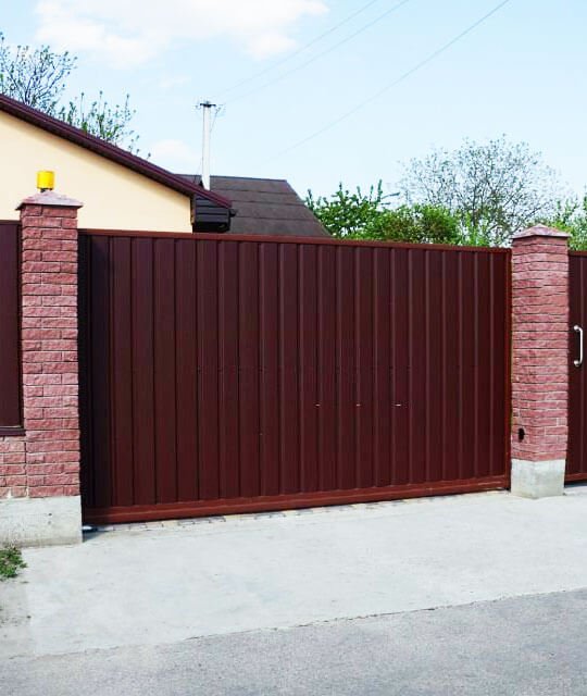 Portón de casa elaborado con lámina tipo tablero