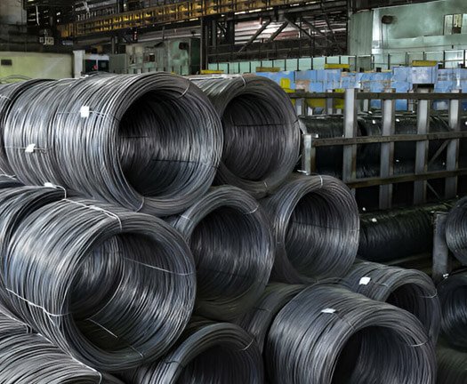 Rollos de alambre recocido colocados unos sobre otros dentro de una fábrica